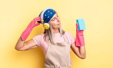 Orta yaşlı, güzel bir kadın şaşkın ve kafası karışık, kaşınıyor. Temizleyici.