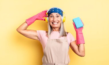 Orta yaşlı, güzel bir kadın stresli, endişeli ya da korkmuş, elleri başının üstünde. Temizleyici.