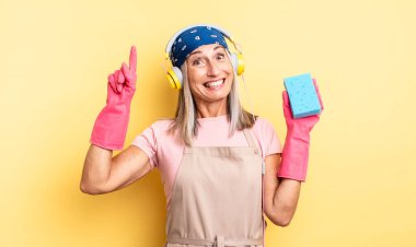 Orta yaşlı, güzel bir kadın bir fikri fark ettikten sonra mutlu ve heyecanlı bir dahi gibi hissediyor. Temizleyici.