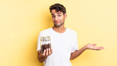 İspanyol yakışıklı adam şaşkın, şaşkın ve şüpheci hissediyor. Kahve şişesi.