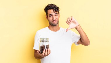 Latin asıllı yakışıklı adam kızgın, baş parmağını kaldırıyor. Kahve şişesi.