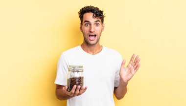 İspanyol yakışıklı adam kendini mutlu hissediyor ve inanılmaz bir şeye hayret ediyor. Kahve şişesi.