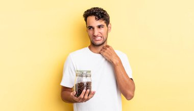 İspanyol yakışıklı adam stresli, endişeli, yorgun ve hayal kırıklığına uğramış hissediyor. Kahve şişesi.