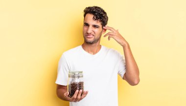 İspanyol yakışıklı adam kafası karışık ve şaşkın hissediyor, senin deli olduğunu gösteriyor. Kahve şişesi.