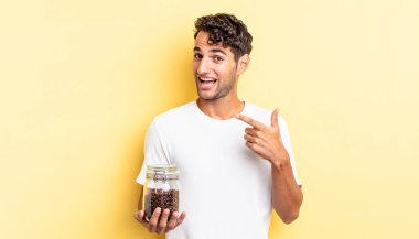 İspanyol yakışıklı adam heyecanlı ve şaşırmış görünüyor. Kahve şişesi.