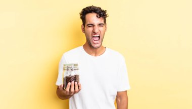 İspanyol yakışıklı adam agresif bir şekilde bağırıyor, çok kızgın görünüyor. Kahve şişesi.