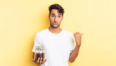 İspanyol yakışıklı adam, inançsızlıktan şaşkın şaşkın bakıyor. Kahve şişesi.