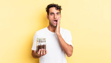 İspanyol yakışıklı adam şok olmuş ve korkmuş hissediyor. Kahve şişesi.