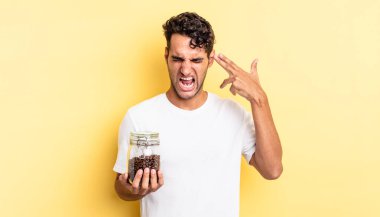 İspanyol yakışıklı adam mutsuz ve stresli görünüyor, intihar jesti silah işareti yapıyor. Kahve şişesi.