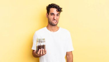 İspanyol yakışıklı adam kafası karışmış ve şaşkın görünüyor. Kahve şişesi.