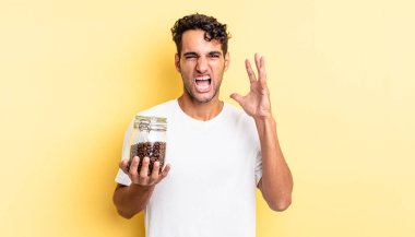 İspanyol yakışıklı adam ellerini havaya kaldırarak bağırıyor. Kahve şişesi.