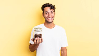 İspanyol yakışıklı adam mutlu ve hoş bir şekilde şaşırmış görünüyor. Kahve şişesi.