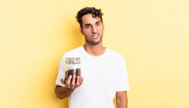 İspanyol yakışıklı adam şaşkın ve şaşkın hissediyor. Kahve şişesi.