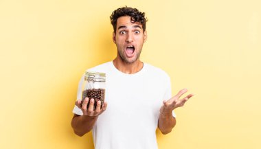 İspanyol yakışıklı adam son derece şaşırmış ve şok olmuş hissediyor. Kahve şişesi.