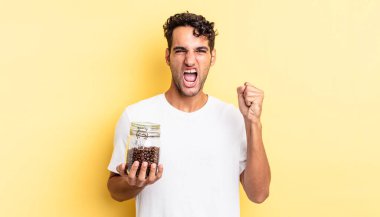 İspanyol yakışıklı adam sinirli bir ifadeyle agresif bir şekilde bağırıyor. Kahve şişesi.