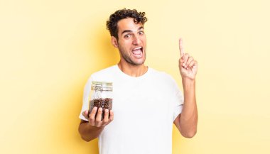 İspanyol yakışıklı bir adam bir fikri fark ettikten sonra mutlu ve heyecanlı bir dahi gibi hissediyor. Kahve şişesi.