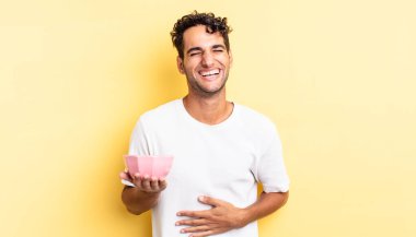 İspanyol yakışıklı bir adam komik bir şakaya yüksek sesle gülüyor. boş kase kavramı