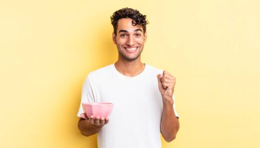 İspanyol yakışıklı adam şokta, gülüyor ve başarıyı kutluyor. boş kase kavramı