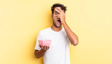 İspanyol yakışıklı adam şok olmuş, korkmuş ya da korkmuş görünüyor. Yüzü elle kapatılmış. boş kase kavramı