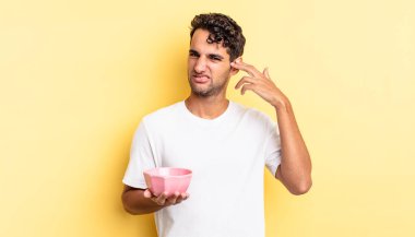 İspanyol yakışıklı adam kafası karışık ve şaşkın hissediyor, senin deli olduğunu gösteriyor. boş kase kavramı