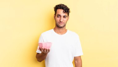 Hispanik yakışıklı adam üzgün, üzgün ya da kızgın hissediyor ve yana bakıyor. boş kase kavramı