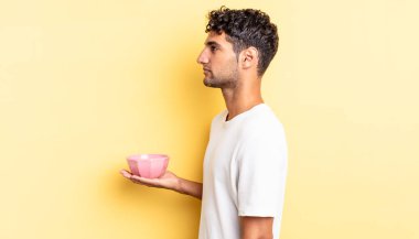 Profil görünümlü İspanyol yakışıklı adam hayal mi kuruyor, hayal mi kuruyor, hayal mi kuruyor? boş kase kavramı