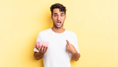 İspanyol yakışıklı adam şok olmuş ve ağzı açık, kendini işaret ederek şaşırmış görünüyor. boş kase kavramı