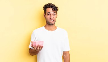 İspanyol yakışıklı adam kafası karışmış ve şaşkın görünüyor. boş kase kavramı