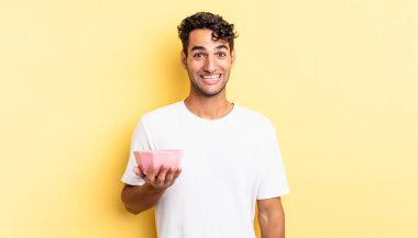 İspanyol yakışıklı adam mutlu ve hoş bir şekilde şaşırmış görünüyor. boş kase kavramı