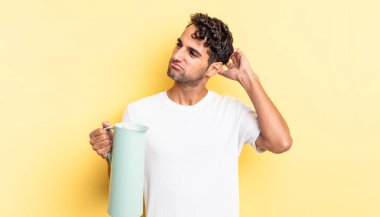 İspanyol yakışıklı adam şaşkın ve kafası karışık, kaşınan bir kafa hissediyor. Kahve termosu kavramı
