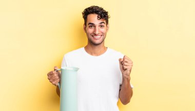 İspanyol yakışıklı adam şokta, gülüyor ve başarıyı kutluyor. Kahve termosu kavramı