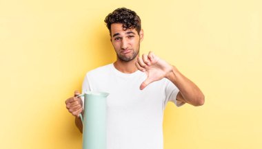 Latin asıllı yakışıklı adam kızgın, baş parmağını kaldırıyor. Kahve termosu kavramı
