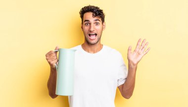 İspanyol yakışıklı adam kendini mutlu hissediyor ve inanılmaz bir şeye hayret ediyor. Kahve termosu kavramı