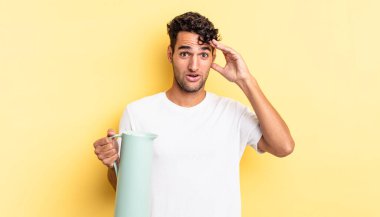 İspanyol yakışıklı adam mutlu, şaşkın ve şaşırmış görünüyor. Kahve termosu kavramı