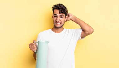 İspanyol yakışıklı adam kendini stresli, endişeli ya da korkmuş hissediyor, elleri başının üstünde. Kahve termosu kavramı