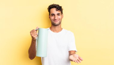 İspanyol yakışıklı adam mutlu bir şekilde gülümsüyor ve bir konsept sunuyor. Kahve termosu kavramı