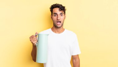 İspanyol yakışıklı adam çok şaşırmış ya da şaşkın görünüyor. Kahve termosu kavramı