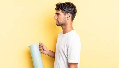 Profil görünümlü İspanyol yakışıklı adam hayal mi kuruyor, hayal mi kuruyor, hayal mi kuruyor? Kahve termosu kavramı