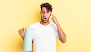 İspanyol yakışıklı adam şaşırmış görünüyor, yeni bir düşünce, fikir ya da konsept fark ediyor. Kahve termosu kavramı