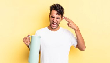 İspanyol yakışıklı adam mutsuz ve stresli görünüyor, intihar jesti silah işareti yapıyor. Kahve termosu kavramı