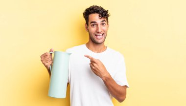 İspanyol yakışıklı adam heyecanlı ve şaşırmış görünüyor. Kahve termosu kavramı