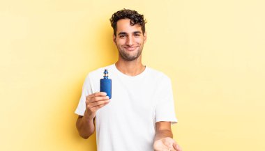 İspanyol yakışıklı adam mutlu bir şekilde gülümsüyor ve bir konsept sunuyor. buharlaştırıcı kavramı