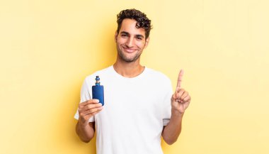 İspanyol yakışıklı adam gülümsüyor ve arkadaş canlısı görünüyor, bir numarayı gösteriyor. buharlaştırıcı kavramı