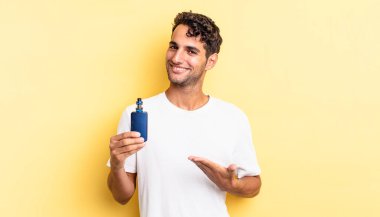 İspanyol yakışıklı adam neşeyle gülümsüyor, mutlu hissediyor ve bir konsept gösteriyor. buharlaştırıcı kavramı