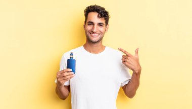 İspanyol yakışıklı adam kendine güvenerek gülüyor ve kendi gülüşüne işaret ediyor. buharlaştırıcı kavramı