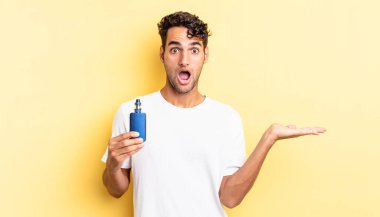 İspanyol yakışıklı adam şaşırmış ve şok olmuş görünüyor. Çenesi düşmüş ve elinde bir nesne var. buharlaştırıcı kavramı