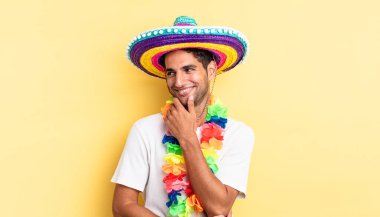 Mutlu, kendine güvenen, elleri çenesinde gülümseyen İspanyol yakışıklı bir adam. Meksika partisi konsepti