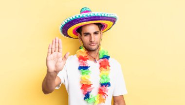 İspanyol yakışıklı adam ciddi görünüyor. Avuç içi gösteriyor. Durdurma hareketi yapıyor. Meksika partisi konsepti