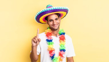 İspanyol yakışıklı adam gülümsüyor ve arkadaş canlısı görünüyor, bir numarayı gösteriyor. Meksika partisi konsepti