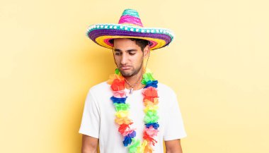 Hispanik yakışıklı adam üzgün, üzgün ya da kızgın hissediyor ve yana bakıyor. Meksika partisi konsepti